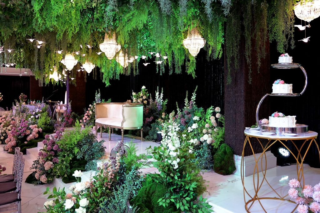 Pelamin dan pelantar kek dikelilingi bunga dan hijau segar di Bizmilla Ariz Hall Putrajaya