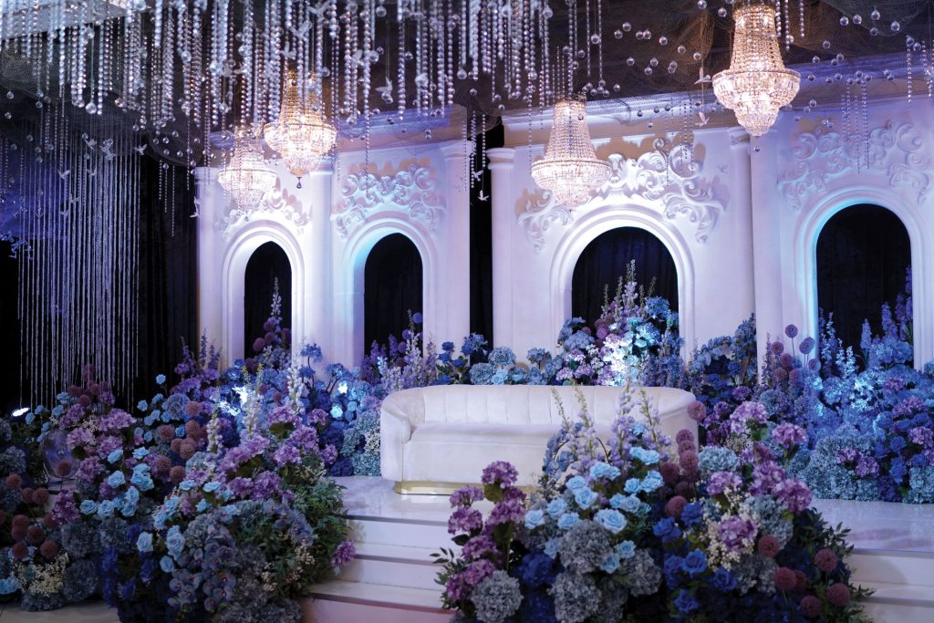 Pelamin putih berlatar gerbang melengkung dan bunga hydrangea di Event Hall Putrajaya