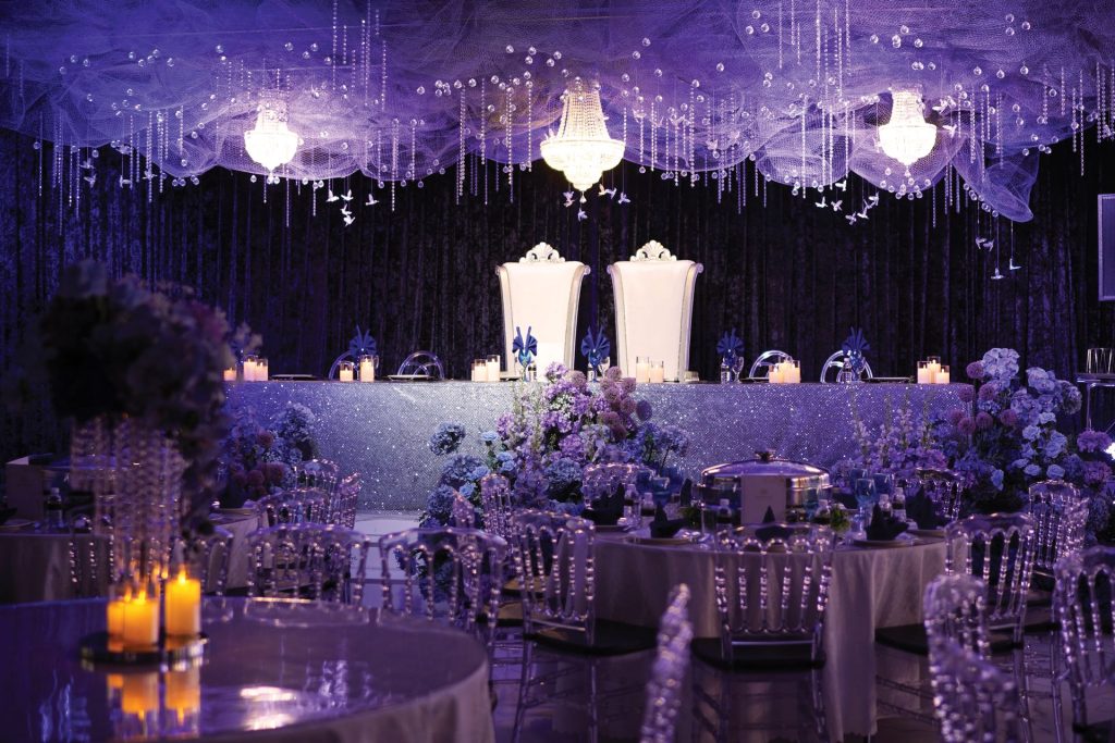 Meja pengantin berhias lilin dan siling tirai kristal ungu di Event Hall Putrajaya
